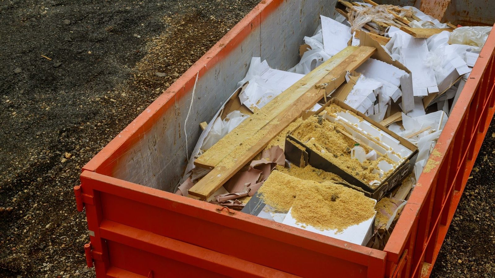 Red dumpster with mixed debris