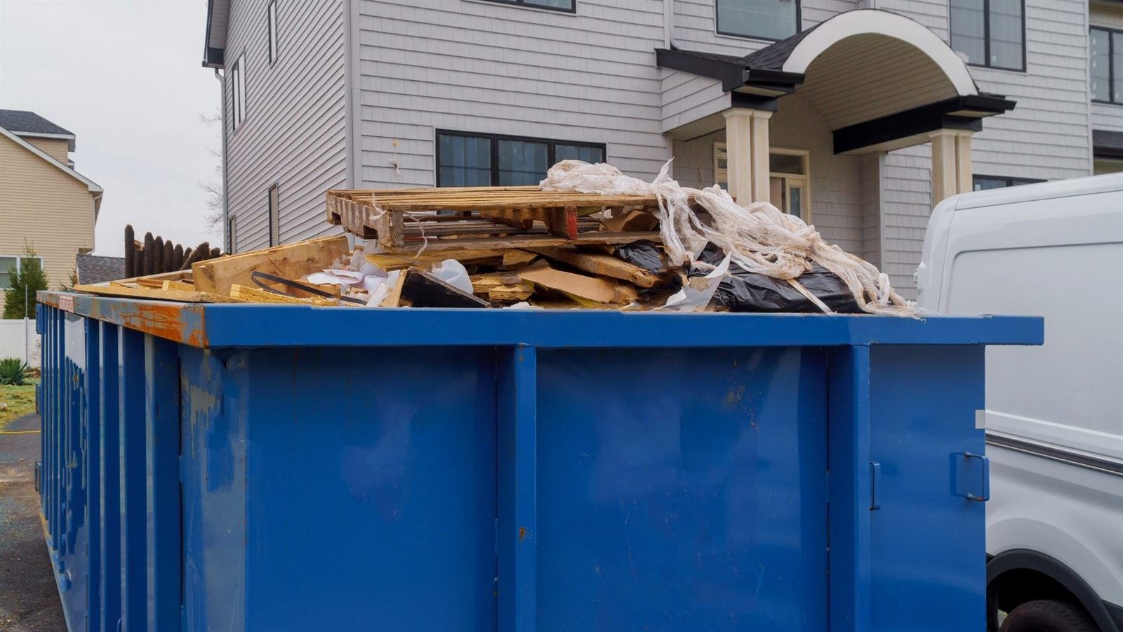 Construction dumpster near new home framing
